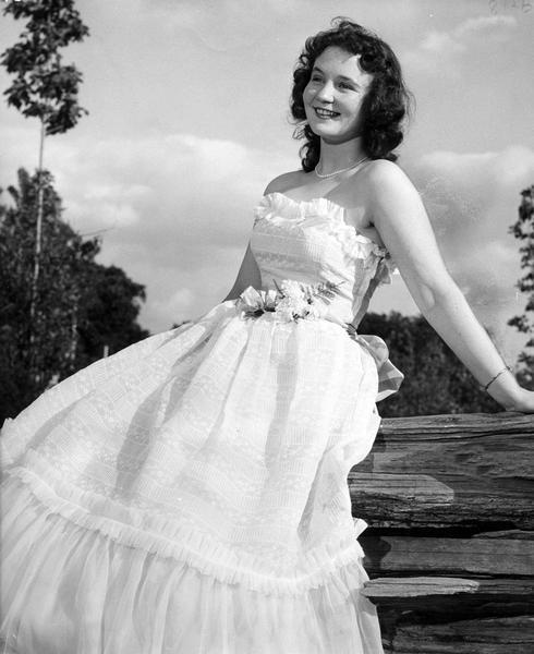 The 1950 Alice in Dairyland, Virgina Ruth Peterson, posed sitting on a fence after she was chosen for the title from a field of 18 in the final judging at the press and radio building at State Fair Park.