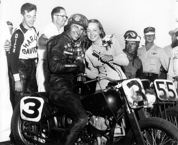 Beverly Steffen, the 1952 Alice in Dairyland, poses with Harley Davidson motorcyle racers and crew at the Wisconsin State Fair.