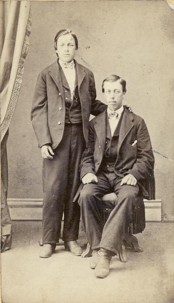 Studio portrait of the Kravig/Kravik sons, one seated and one standing.