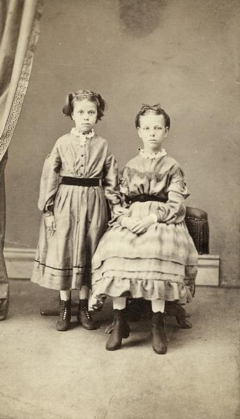 Studio portrait of the Kravig/Kravik daughters, one seated and one standing.