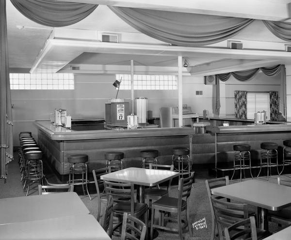 Interior view of the Esquire Club dining room including a soda fountain counter with a countertop jukebox. There is a piano in the background. 2615 Sherman Avenue.