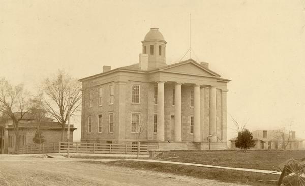 Exterior view of the Dane County Courthouse, which was erected in 1850 and demolished in 1883, with the County jail to the right.