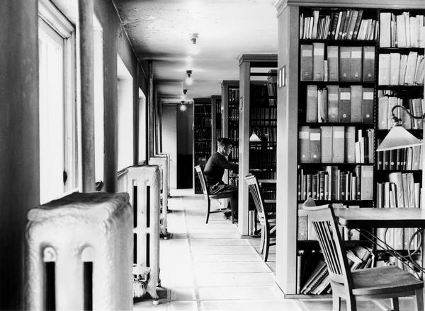 Young man studying at a table in the library stacks of the Wisconsin Historical Society library.