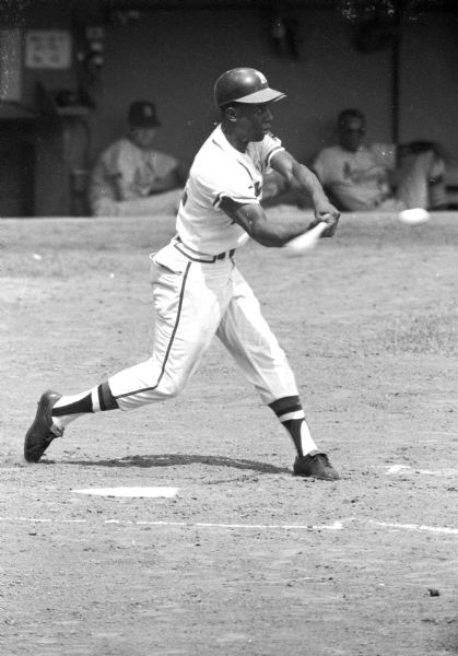 Henry Aaron swinging a baseball bat during a game.