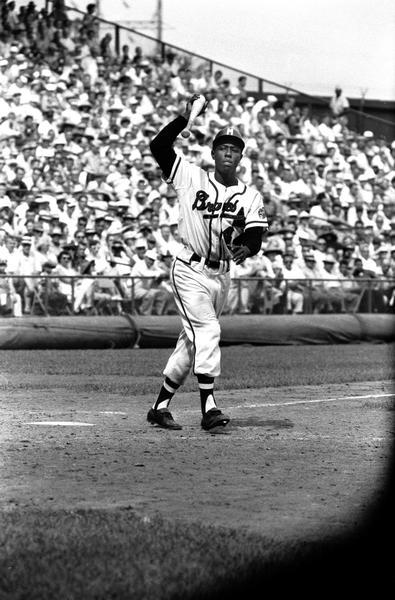 Henry Aaron throws the bat down after his at bat.