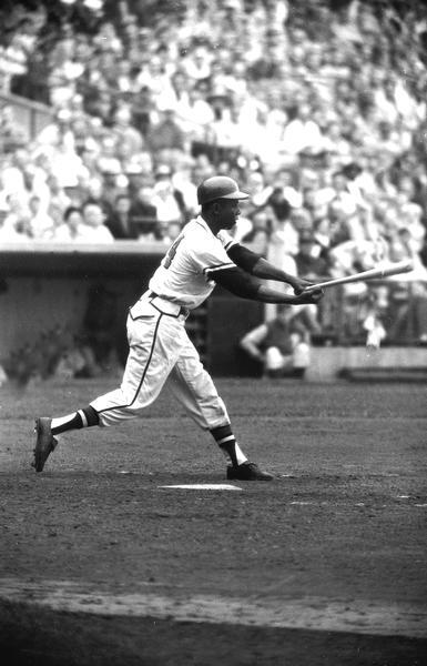 Henry Aaron with a baseball bat in mid-swing.