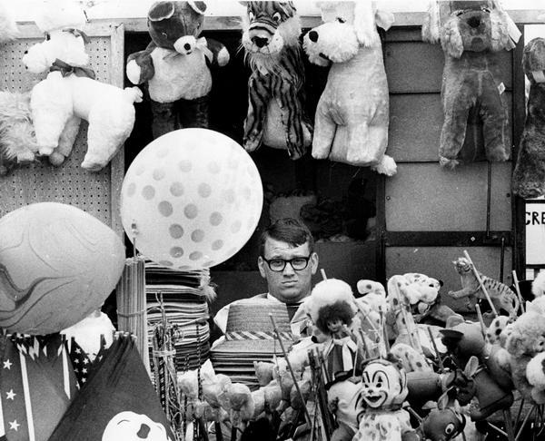 Gary Ksicinski is surrounded by stuffed animals and other souvenirs as he waits for customers at his concession booth at the annual Muskego VFW fair.