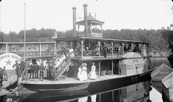 Passengers pose on the <i>New Dell Queen</i> steamboat. Steamboat <i>Alexander Mitchell</i> in background.