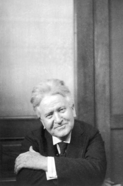 Candid portrait of Robert M. La Follette, Sr., smiling, with his arms crossed during the 1922 senatorial campaign.  This snapshot is one of a series taken by Madison writer/photographer Fred Holmes, who also worked in various editorial capacities with La Follette's Magazine (later the Progressive Magazine).  It is likely that the photographs were taken in the magazine office.