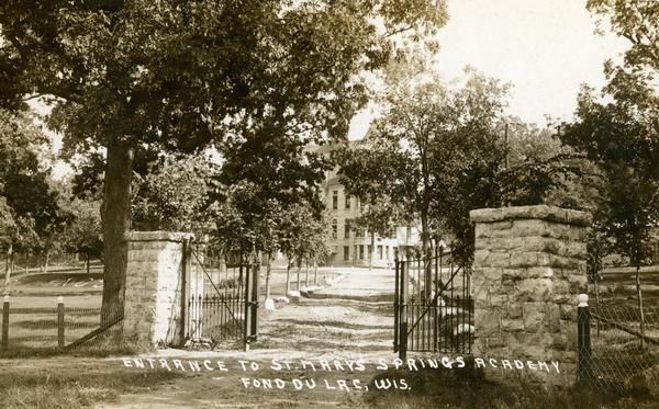 The stone and iron gateway entrance to St. Mary's Springs Academy. Caption reads: "Entrance to St. Mary's Springs Academy Fond du Lac, Wis."