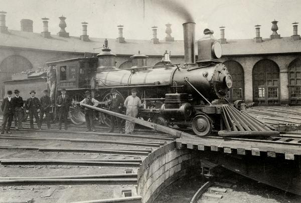 Chicago, Milwaukee & St. Paul Locomotive #280 at the Madison roundhouse. Identified railroad employees posed outdoors with the locomotive include: fireman Omro B. Mills on the gangway, and (left to right) fireman P.D. Connelly, James Schelgham, and Frank Buchahan; switchman "Duck" Murphy; fireman Ed Schewenk; yard foreman Paul Dweites; engineer Jack Fitzgerald, and engineer Theo Torgeson.