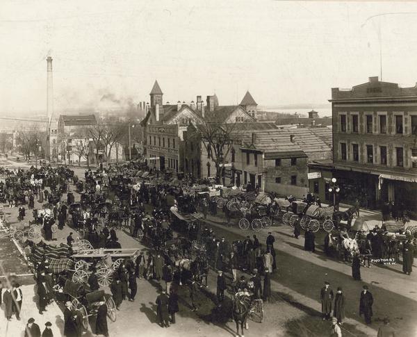 East Washington Avenue crowded with people and horse-drawn vehicles.