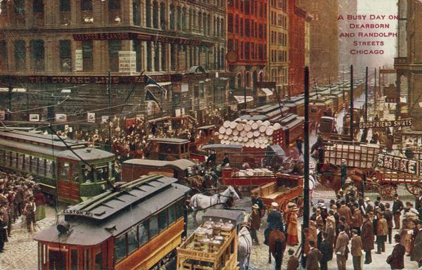 Elevated view of Randolph and Dearborn Streets crowded with people, streetcars, and horse-drawn vehicles. Caption reads: "A Busy Day on Dearborn and Randolph Streets, Chicago."
