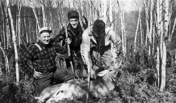 Hunters Harold Vandervort, Tom Massengase, and John Voell pose with deer carcass. Original caption reads: "Deer taken by John R. Voell, 226 Bank St., Fond du Lac in Marinette County Sec. 8--Town 35--Range 20 on Sunday Oct. 10, 1943. Estimated 220 to 228--actually dressed at 177. 10 Point. One arrow at base of neck at 30 yards--running shot. 57 lb. bow."