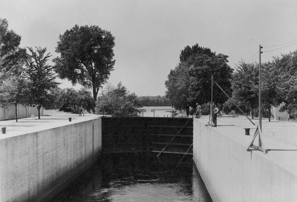 Men are standing at the Canal locks.