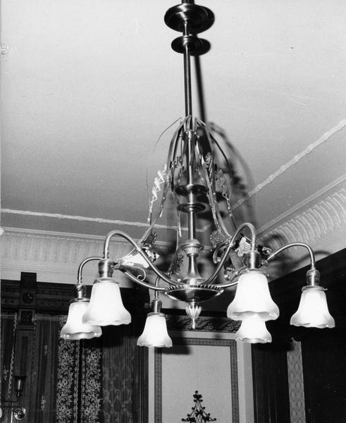 Original brass chandelier with art glass shades hangs in "Hearthstone," the home built by paper mill owner, Henry J. Rogers. The residence was the first dwelling electrified from a centrally located hydorelectric plant.