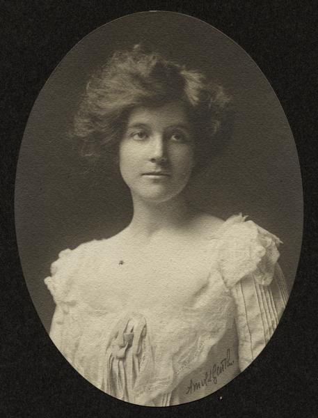 Oval-framed quarter-length studio portrait of young Zona Gale in a white dress.