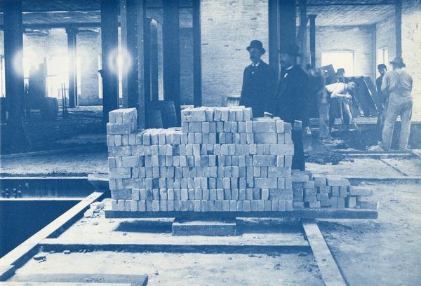 Interior of State Historical Society of Wisconsin during construction. Image shows bricks used in the building and workers.