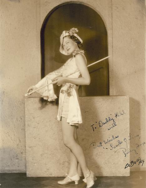Dancer Ruby Faye posed with a cane used as a dance prop.  Ruby Fay was at one time a student of F.W. Kehl of the Kehl School of Dance in Madison, and the print is inscribed "To 'Daddy' Kehl with Best Wishes 'n Loads of Love, Ruby Faye."