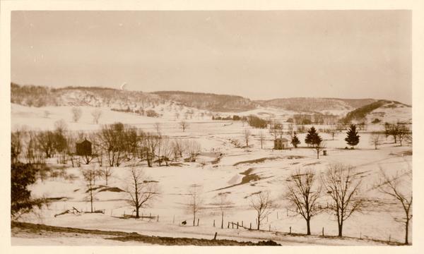 Two farmhouses and the surrounding snowy landscape near Taliesin, the home of Frank Lloyd Wright. 