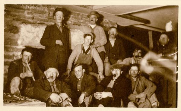 Workmen who worked on the construction of Taliesin I gathered in the workroom in front of the fireplace. Taylor Woolley's brother-in-law Clifford (Cliff) Evans is sitting in the center on the bottom row. Taliesin is located in the vicinity of Spring Green, Wisconsin.