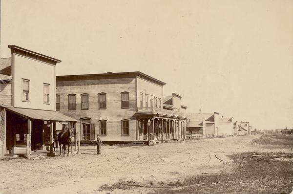 Exterior view of the Post Office, with boy and horse in front.