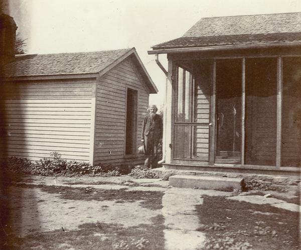 John Lloyd Jones standing between his house and the post office shed.