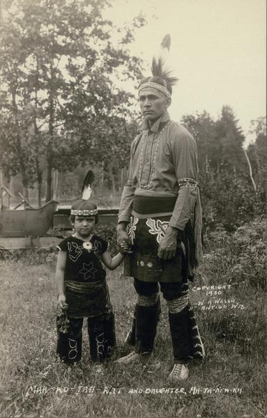 Nah-Ko-Tah-Rat and his daughter Ah-Ta-New-Ka pose together in traditional Indian clothing.