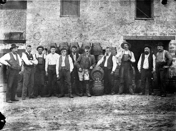 Brewery employees, many of them from the Schumacher family, posing with barrels outside the brewery.