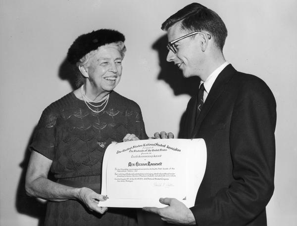 Eleanor Roosevelt and Ray Farabee holding a certificate together, which he presented to her at AAUN.