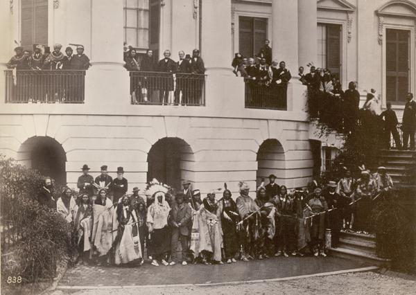 President Andrew Johnson and members of various Indian delegations and the White House staff pose outside the White House together.