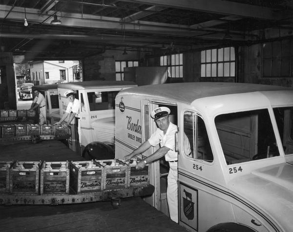 Borden workers loading milk onto trucks at the Borden Company loading dock.