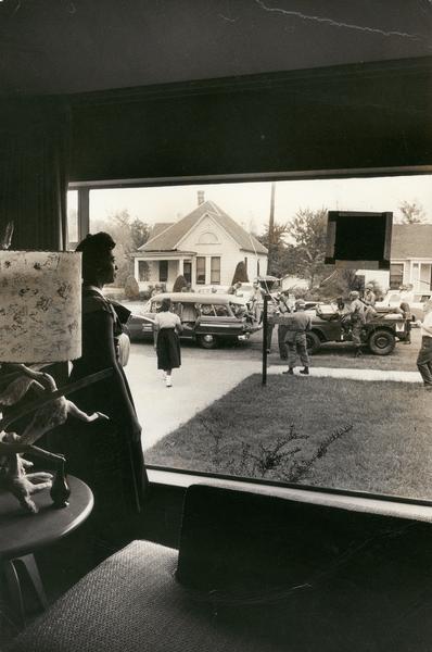 Daisy Bates looks out from her front window as members of the 101st Airborne Division prepare to escort members of the "Little Rock Nine" to Central High School.
