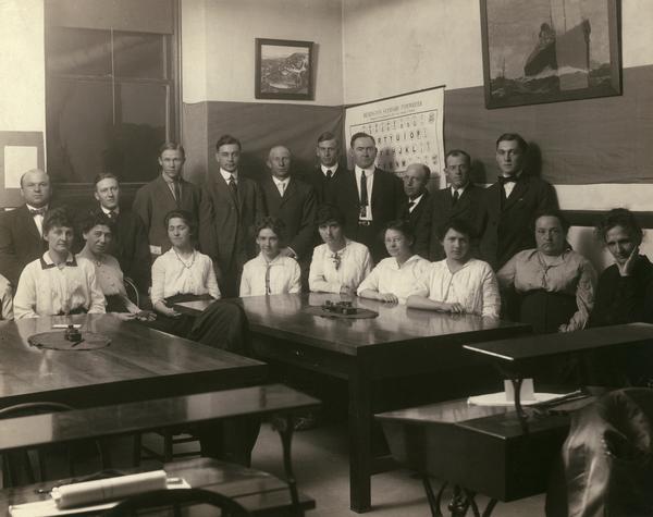 A University Extension Accounting class posing in the classroom, with men standing and women seated. Included are Berhart, Jackson, Ollinger, Stewart, Keith, Weiterman, Langmas, Johnson, J. Johnson, Washburn, Wagener, Fetzer, Ridgley, La Mere, Nelson, Anschutz, Reynolds, and Johnson.