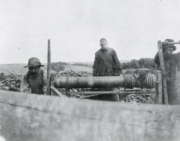 An unidentified mining scene where two men are cranking a windlass, common only in early lead and zinc mining in southwest Wisconsin. The windlass was used to lower and bring up men from mining many feet below.