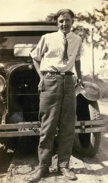 Portrait of Angus "Mac" McVicar, age 20, in front of the new family car. The photograph was probably taken by his father while the family was on vacation.