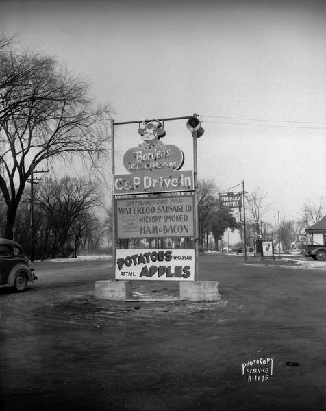 C & P Drive-In market sign, 3830 Atwood Avenue, featuring Borden's Ice Cream and Waterloo Sausage Co. Also shows John Olson's Standard Service Station sign in the background to the right. The location is the corner where Atwood Avenue ends, Monona Drive begins, and Cottage Grove Road (Co. Highway B) goes off to the east.