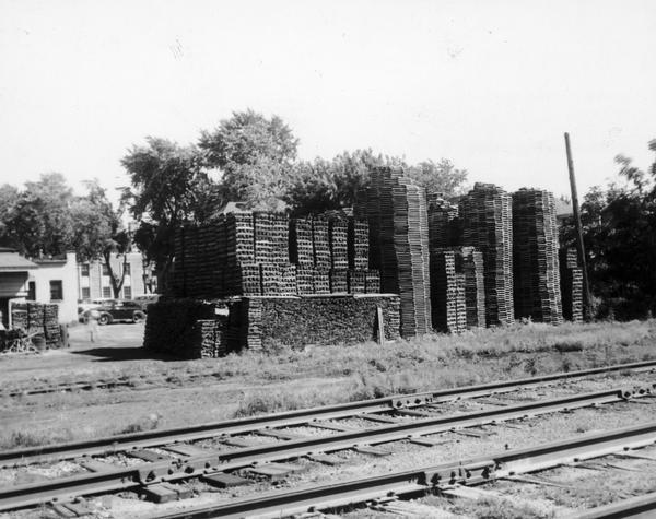 Stacks of oak barrel staves and heads curing outdoors behind the Hess Cooperage, near Atwood Avenue. The round stacks are the heads and the square stacks are staves.