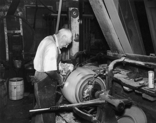 Frank Hess Sr., owner of Hess Cooperage, finishing the exterior of a barrel on a cooper's lathe.