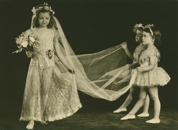 Virgina Lee Kehl and twins Jo Ann and Jo Jean Kehl perform in a bridal number in costumes designed and crafted by Mrs. Genevieve Kehl.