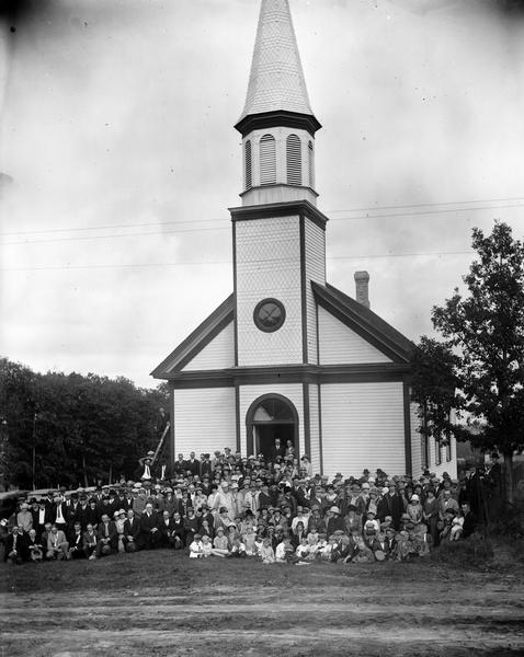 Exterior view of Newport Church, with the congregation gathered in front.