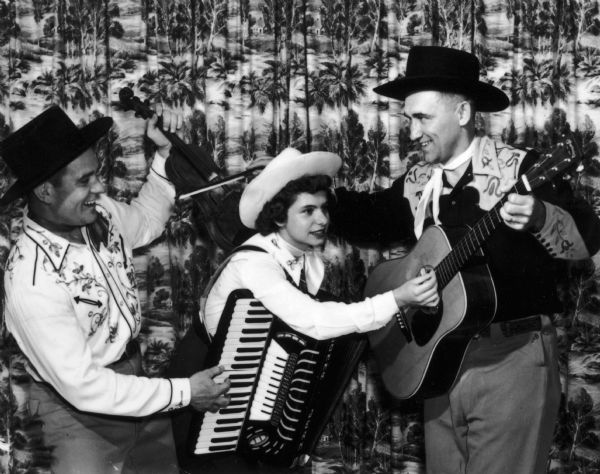The Hoedowners, a country western trio consisting of Wendell "Wendy" Whitford, fiddleplayer; Donna Jean Lundeberg, piano accordian; and Vern Minor, guitar, playing each other's instruments.