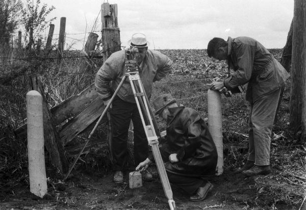 Three men surveying a point in southwestern Wisconsin.