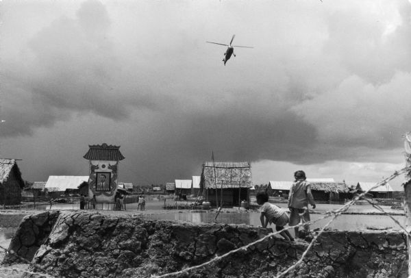 Little boys watch the arrival of a helicopter over Binh Mung village in Vietnam.