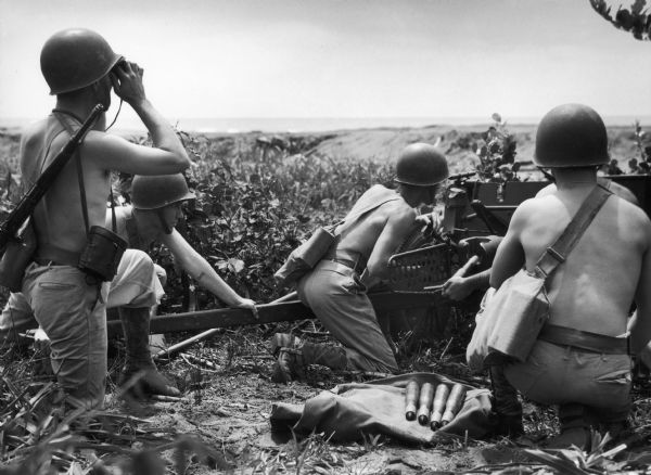 The four shirtless men in helmets shown with ammunition are a general and his crew of the 14th infantry in Panama.