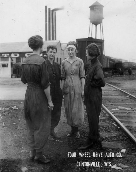 Four women workers standing in front of the Four Wheel Drive Factory.