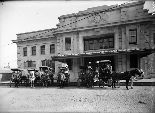 Horse-drawn American Express wagons in front of the Chicago & Northwestern Railway depot.