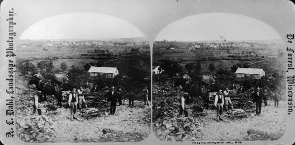 Probably one of the "Three different views of the village of Argyle, Wis." mentioned in Dahl's 1877 "Catalogue of Stereoscopic Views." Eleven men and boys stand near a rock quarry with the town of Argyle in the background.