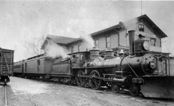 Chicago, Milwaukee, and St. Paul Railroad train at the old station, 640 West Washington Ave., with snowplow at the old depot.  Engineer James F. Mills is in the cab window.