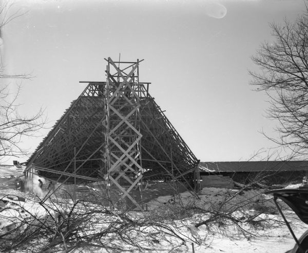 The First Unitarian Society Meeting House during construction, as viewed from University Bay Drive, with the roof trusses of the auditorium in place. The building was designed by Frank Lloyd Wright and built by Marshall Erdman.
